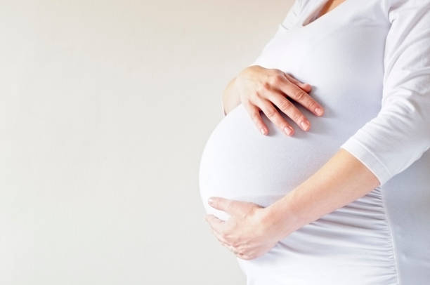 Mulher grávida segurando a barriga - foto de acervo