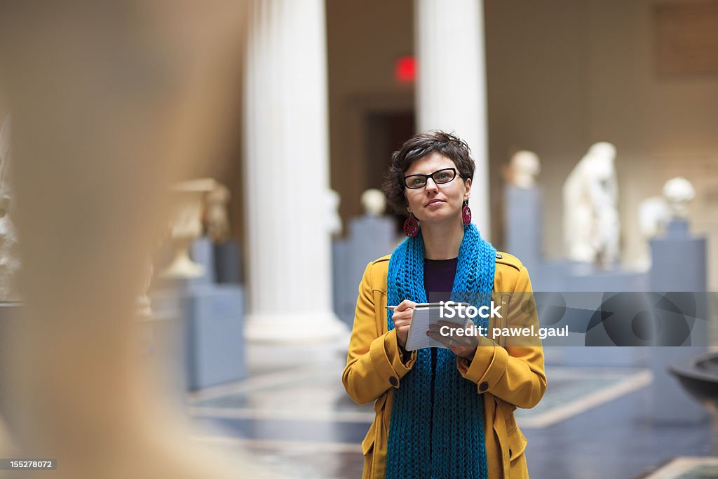 Young woman in museum Woman in museum takes notes as she is looking at fine art statue.

***PLEASE TAKE YOUR TIME TO TELL ME WHERE MY IMAGE WAS USED*** Museum Stock Photo