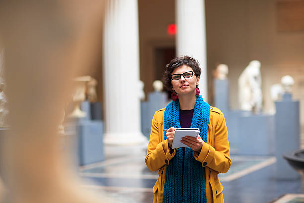 Young woman in museum Woman in museum takes notes as she is looking at fine art statue.

***PLEASE TAKE YOUR TIME TO TELL ME WHERE MY IMAGE WAS USED*** sculpture photos stock pictures, royalty-free photos & images
