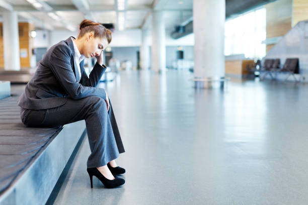 istock Frustrated Businesswoman Sitting at Baggage Claim 155278371