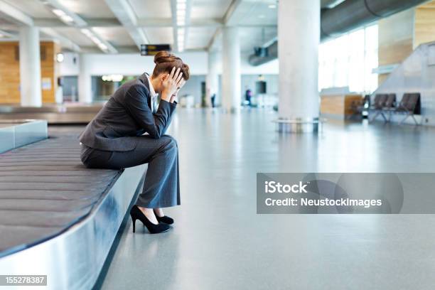 Verärgert Geschäftsfrau Sitzen An Der Gepäckausgabe Stockfoto und mehr Bilder von Flughafen