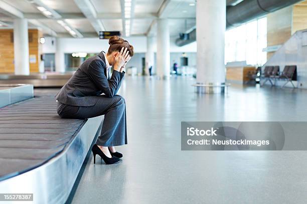 Frustrado Empresaria Sentado En El Área De Reclamo De Equipaje Foto de stock y más banco de imágenes de Aeropuerto