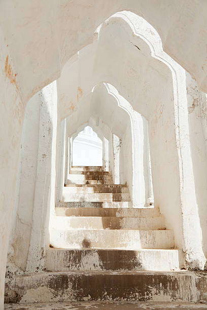 Bottom up view of an old and abandoned house showing signs of antiquity with the staircase, windows and doors