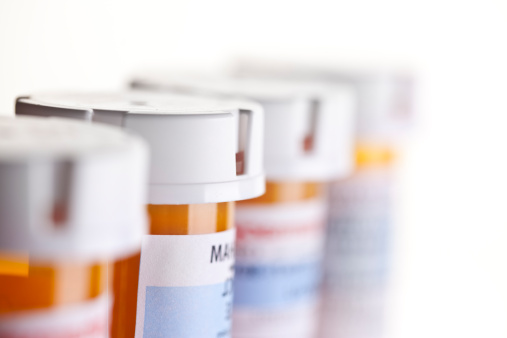 Prescription Bottles in a row on white. Shallow depth of field.