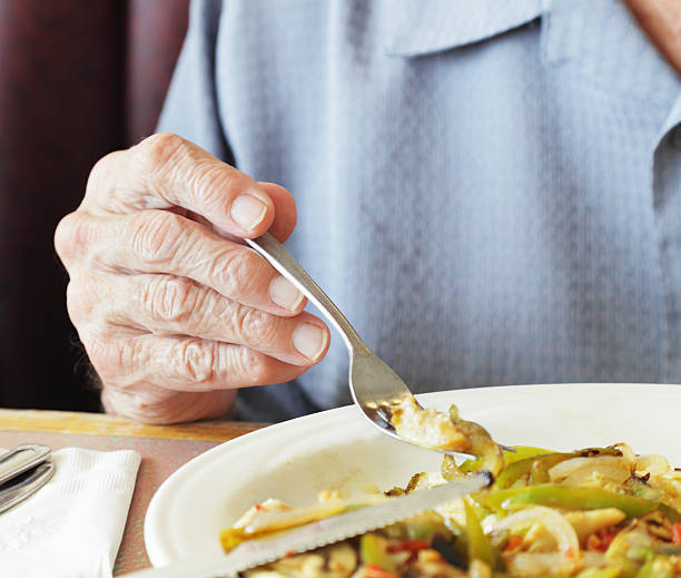 Senior Man Fingers Holding Breakfast Fork Close-Up stock photo