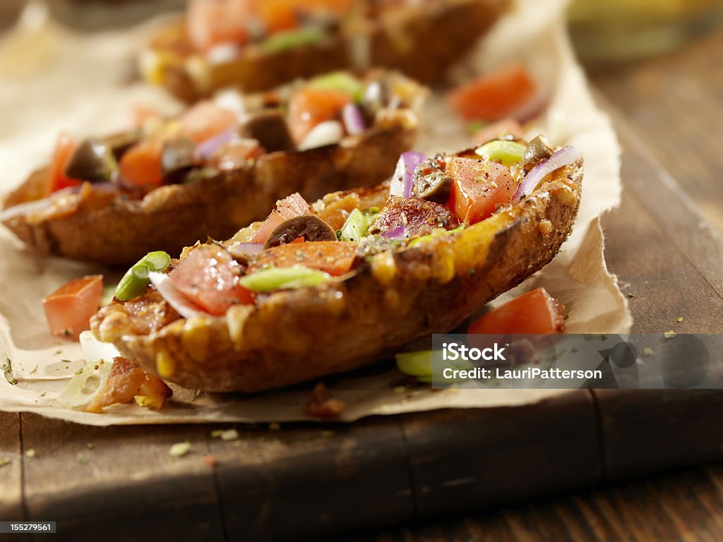 Loaded Stuffed Potato Skins Bacon and Cheddar Stuffed Potato Skins with Tomatoes, Red Onions, Black Olives and Green Onions -Photographed on Hasselblad H3D-39mb Camera Baked Potato Stock Photo