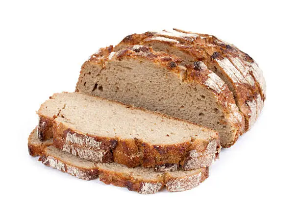 Sliced crusty whole wheat bread on white background