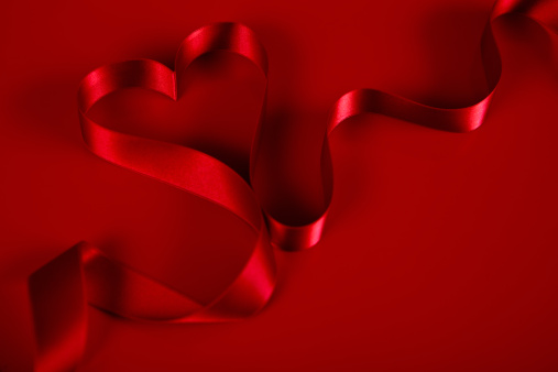 Heart shaped Ribbon on red background.
