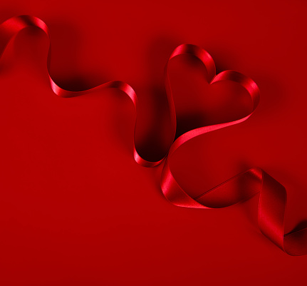 Heart shaped Ribbon on red background.