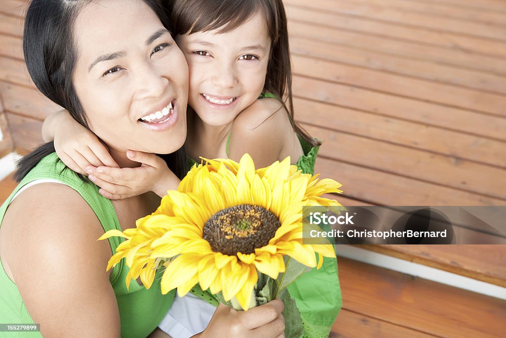 Madre e figlia con girasoli - Foto stock royalty-free di 25-29 anni