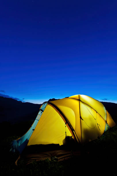 istock Stars shining above yellow dome tent mountain peaks 155279908