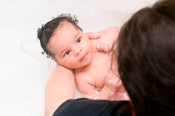 istock Mother Is Bathing Her Newborn Baby (1 month old) 155280369