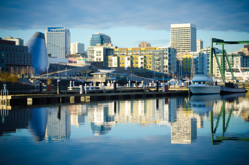 Skyline consisting of office buildings, condominiums and museums of Tacoma, WA reflects off of the Foss Waterway. 