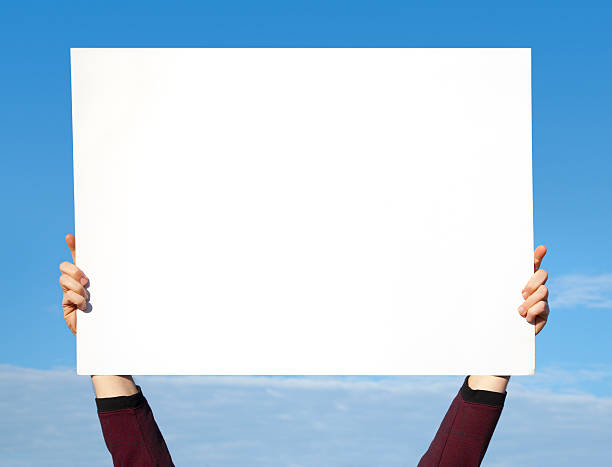 Hands Holding Blank White Sign in Sky stock photo