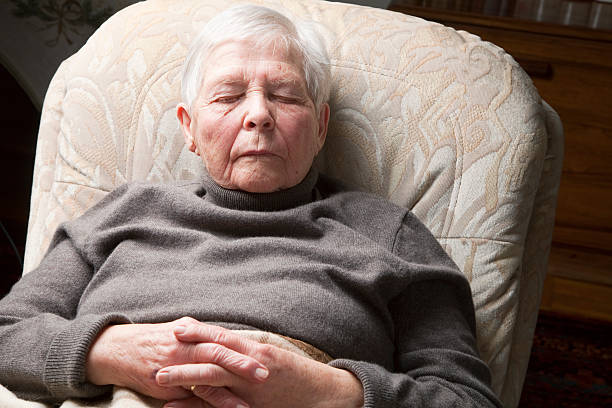 istock senior woman sleeping in chair 155280537
