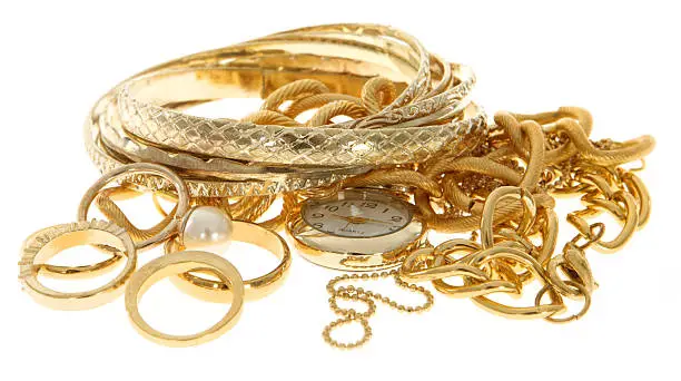Photo of A pile of scrap gold jewelry on a white background