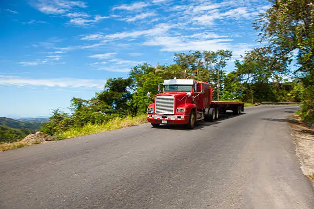 Truck driving on Panamericana Highway through winding roads in Costa Rica, Central America. Panning, Slightly Motion Blured Truck.