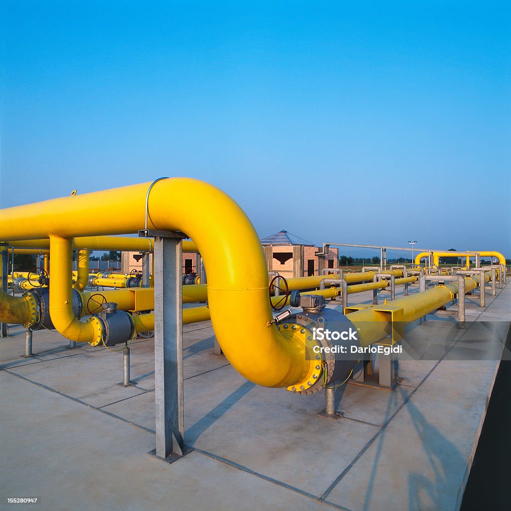 Tubi gas giallo in una stazione di distribuzione, cielo blu sfondo - Foto stock royalty-free di Oleodotto