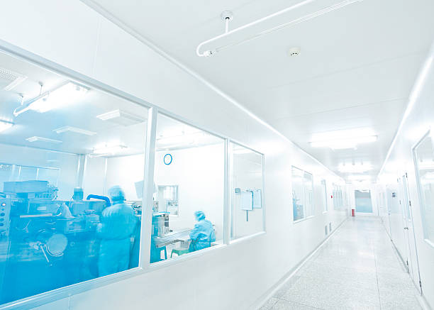clean room in pharmaceutical factory clean room in pharmaceutical factory with unrecognizable technician in blue drug manufacturing stock pictures, royalty-free photos & images