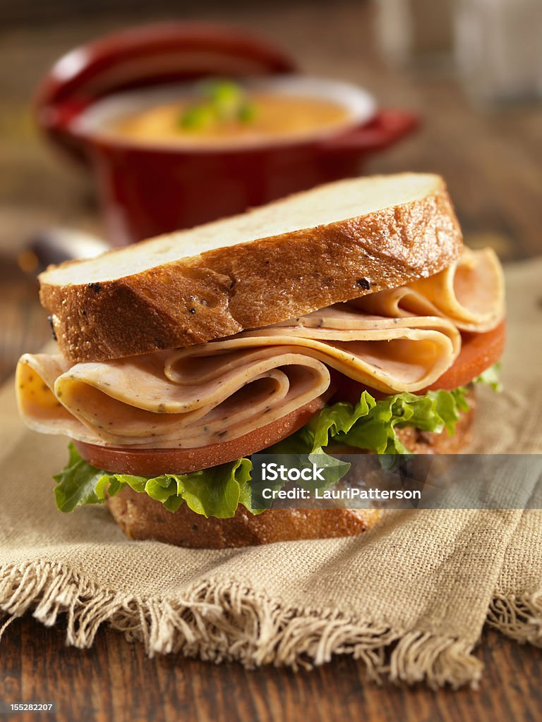 Turkey Sandwich and Tomato Soup Spicy Turkey Sandwich on Whole Grain Bread with Lettuce and Tomatoes and Tomato Soup - Photographed on Hasselblad H3D2-39mb Camera Sandwich Stock Photo