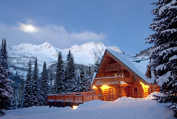 Mountain Lodge in Winter A winter scenic of a rustic, timber-framed lodge in the Canadian backcountry. Horizontal colour image. British Columbia, Canada. Rocky Mountains. Image taken at night with log cabin structure lit with moonlight and starlight.  british columbia photos stock pictures, royalty-free photos & images
