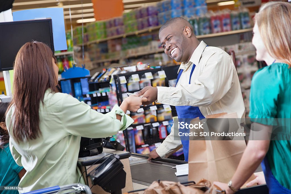 Grocery store клерк передачи принимает оплату от клиентов - Стоковые фото Монета роялти-фри