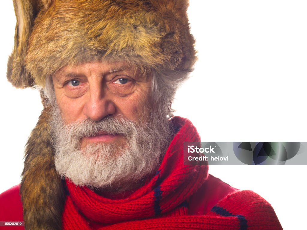 Prepaired for winter Portrait of a mature man with a grey beard and a fur cap, tibetan fox fur and red skarf. Red Stock Photo