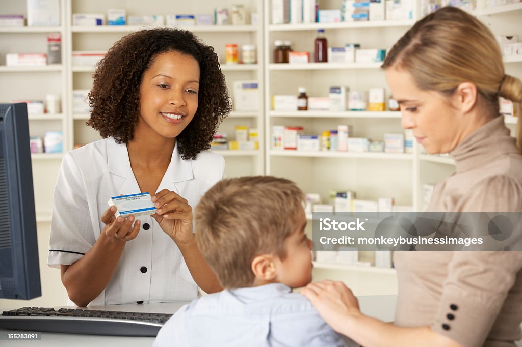Фармацевта в аптеке с Мать и ребенок - Стоковые фото Аптека роялти-фри