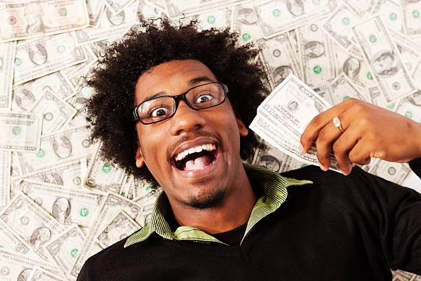 istock Rolling in money! Young man with multiple dollars is triumphant 155283472