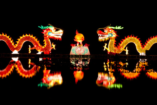 Traditional Chinese dragon lights for Chinese new year. Two dragons are playing with a pearl in the lake, isolated on black ground