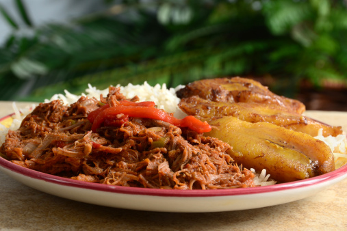 Ropa Vieja is a classic Cuban stew of shredded beef, served here with white rice and fried plantains.