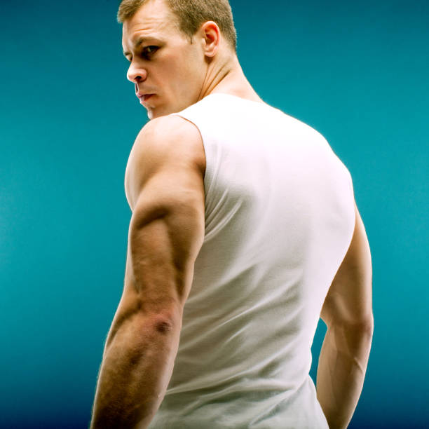 Young Muscular Bodybuilder Guy Doing Exercises With Dumbbells Over White Background