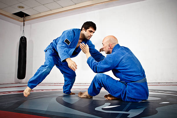 двое мужчин в докладе jiu-jitsu обучение - mixed martial arts combative sport jiu jitsu wrestling стоковые фото и изображения