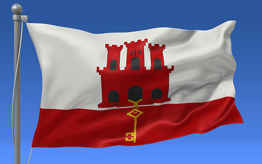 Gibraltar flag waving on the flagpole on a sky background