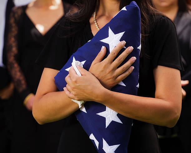 mujer sosteniendo una bandera de funeral - graveside service fotografías e imágenes de stock