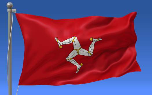 Isle of Man flag waving on the flagpole on a sky background