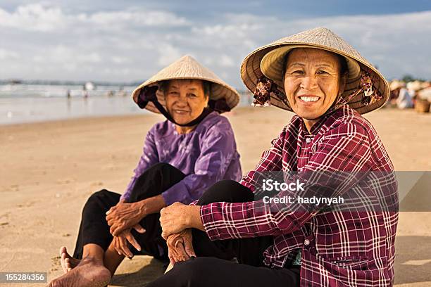 Photo libre de droit de Deux Femmes Vietnamiennes Assis Sur La Plage banque d'images et plus d'images libres de droit de Vietnam - Vietnam, Culture vietnamienne, Personne humaine