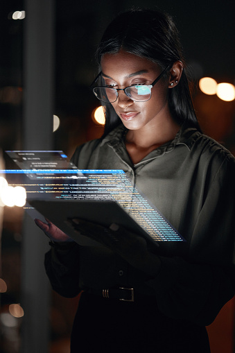 Woman, tablet and hologram at night in web design with dashboard, interface or hud display at the office. Female person, employee or developer working late on futuristic technology or code overlay