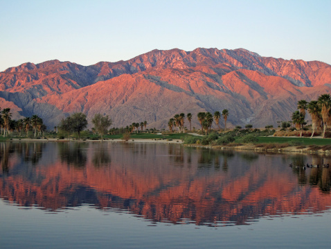The mountains are kissed by the sunrise on a desert golf course near Palm Springs, California.