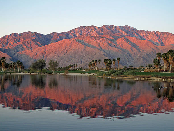Golf course at dawn with sunrise kissed mountains stock photo