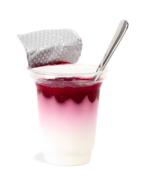 cherry yogurt con cucchiaio all'interno isolato su bianco - yogurt container foto e immagini stock