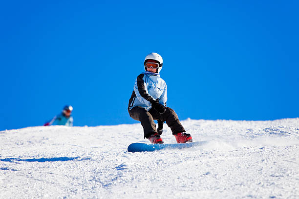 adolescente snowboarding on sunny winter día - snowboarding snowboard women teenager fotografías e imágenes de stock