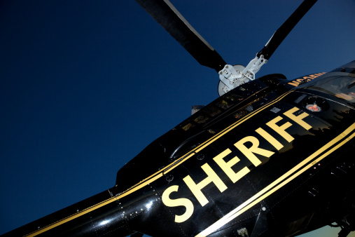 Helicopter hovering above the airfield with man on rope. Photo taken in non ticket area Miramar Airbase in San Diego California USA on September 23, 2022.