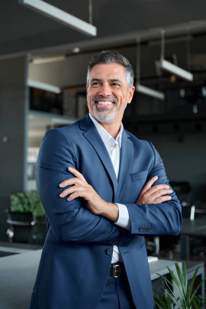 istock Happy middle aged business man standing in office, vertical portrait. 1552851623