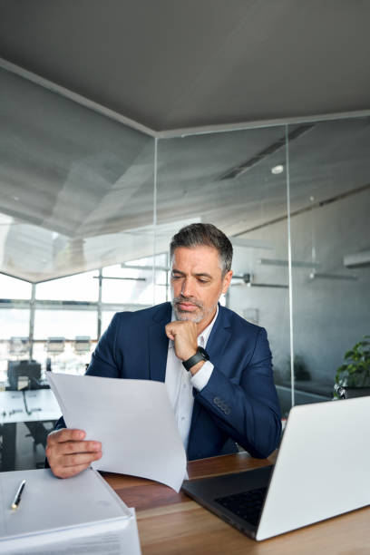istock Busy middle aged business man checking financial documents in office. 1552851646