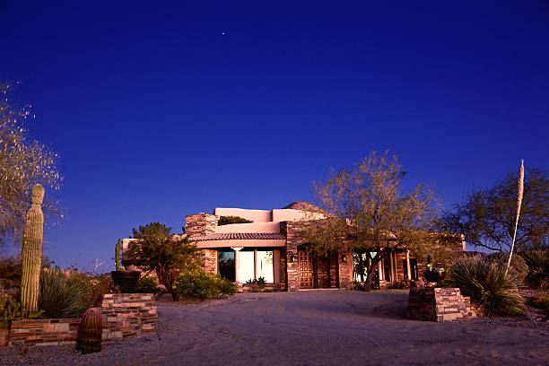 Luxury Arizona Southwest Home in Desert of North Scottsdale Luxury North Phoenix and Scottsdale, AZ modern stone and adobe home  in a desert landscape setting on a clear sky at twilight, clear blue night sky cottonwood tree stock pictures, royalty-free photos & images