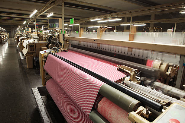 Close-up of purple cloth at textile equipment's conveyor belt.