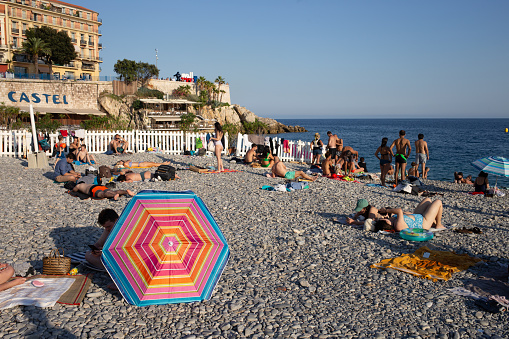 Nice, France - 11July 2023 - vacationers on the Castel beach. pebbly coast of the riviera in the evening