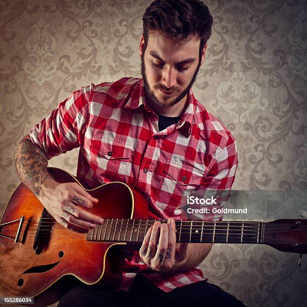 Giovane Uomo Che Suona Una Chitarra Vintage - Fotografie stock e altre immagini di A quadri - A quadri, Abbigliamento casual, Abbigliamento elegante