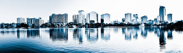 Orlando Downtown Panoramic View, Lake Eola, Reflection Panoramic view of Orlando downtown. Reflections into Lake Eola. Early morning. lake eola stock pictures, royalty-free photos & images